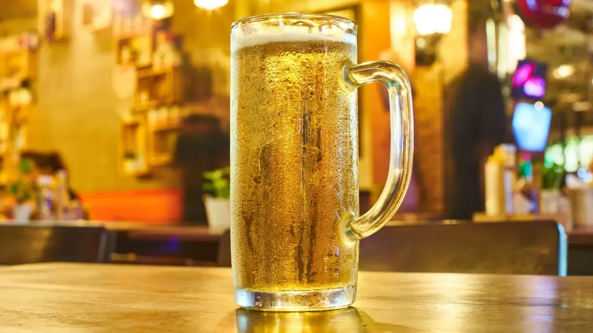 Beer bottles lined up with a rising price tag symbolizing Karnataka's tax hike impact.